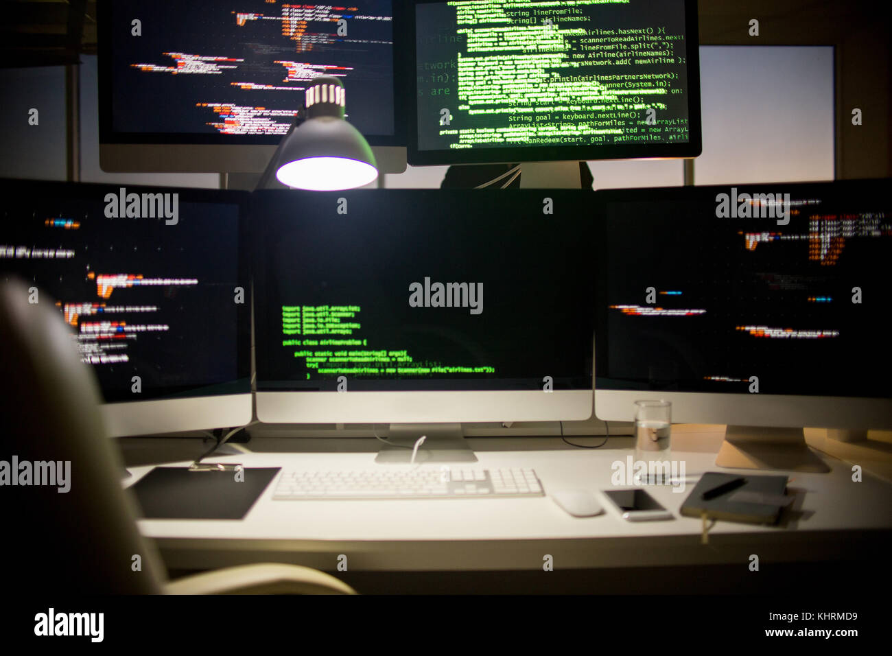 Moderni posti di lavoro di sviluppatore software: cinque schermi con linguaggio di programmazione simboli, accogliente sedia, notepad, finestra panoramica sullo sfondo Foto Stock
