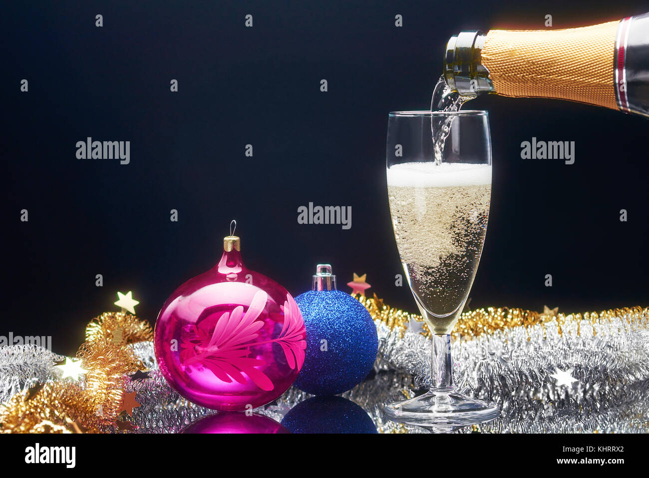Anno nuovo vetro di champagne e decorazioni su sfondo scuro Foto Stock