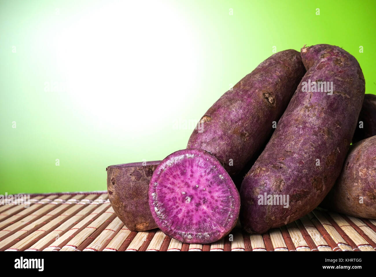 Viola le patate dolci su una tabella con sfondo verde - primo piano Foto Stock