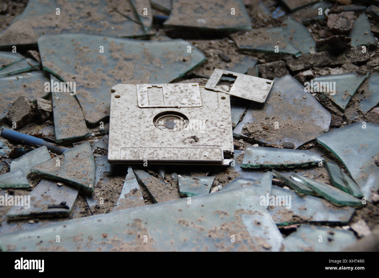 Distrutto, dimenticati e abbandonati i floppy disc. vintage technologies - 3,5 pollici a disco in caso di plastica sul vetro rotto dello sfondo. Foto Stock