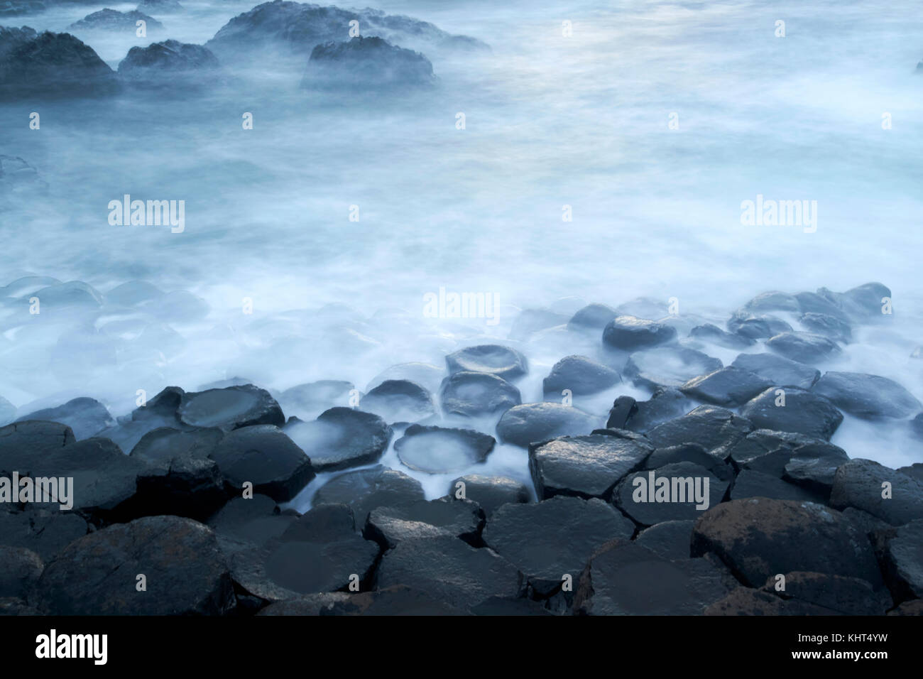 Rocce nel crepuscolo serale con mare lattiginoso, a causa della lunga esposizione al Giants Causeway County Antrim Irlanda del Nord Regno Unito Foto Stock