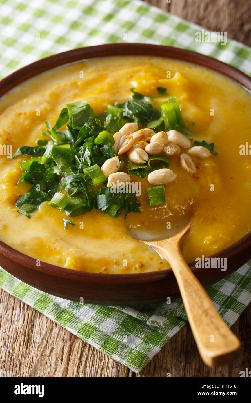 Thai curry di zucca minestra con noccioline e coriandolo vicino sul piano verticale. Foto Stock