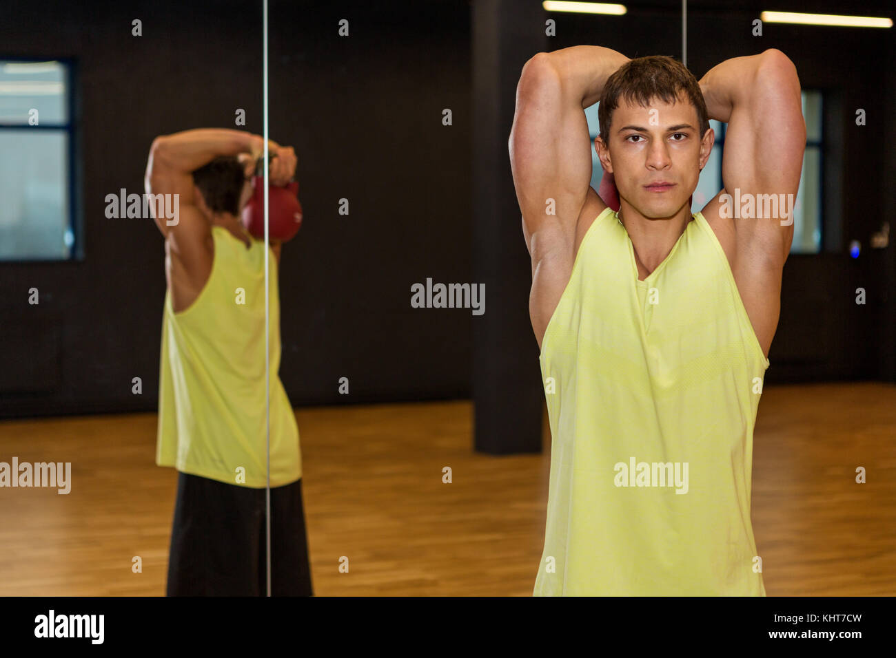 Giovane uomo allenamento con i pesi nella palestra Foto Stock