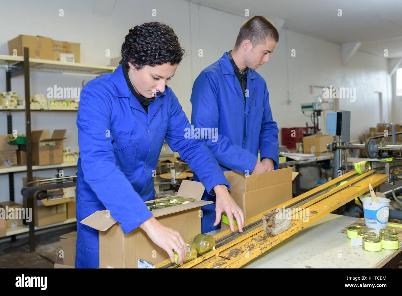 I giovani lavoratori il confezionamento di prodotti al di fuori della fabbrica di linea di produzione Foto Stock