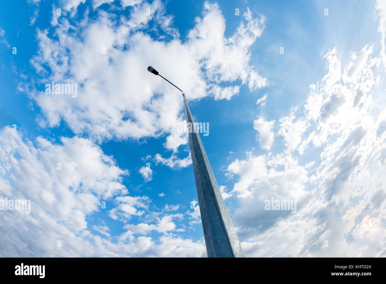 Basso angolo di visione metallico di lampione contro nuvoloso cielo blu Foto Stock