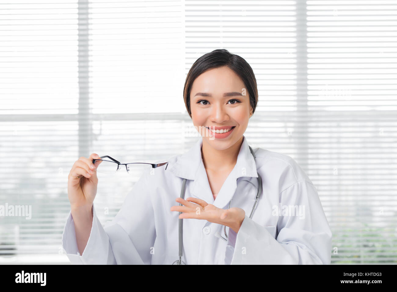 Oculista femmina dando un paio di occhiali Foto Stock