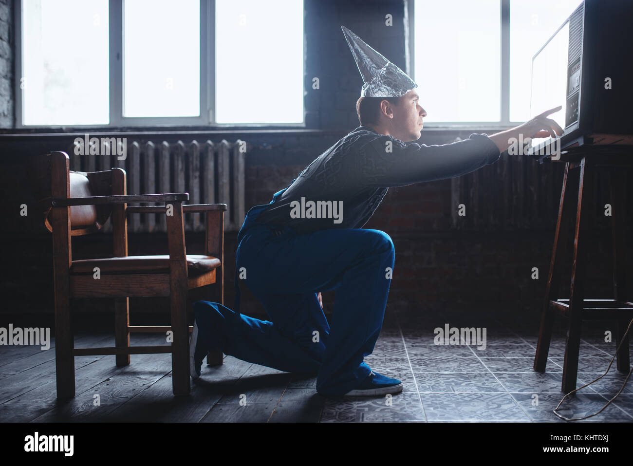 Strano uomo nel tappo di stagnola raggiunge la tv, la paranoia concetto. ufo, la teoria del complotto, cervello protezione contro furto, fobia Foto Stock