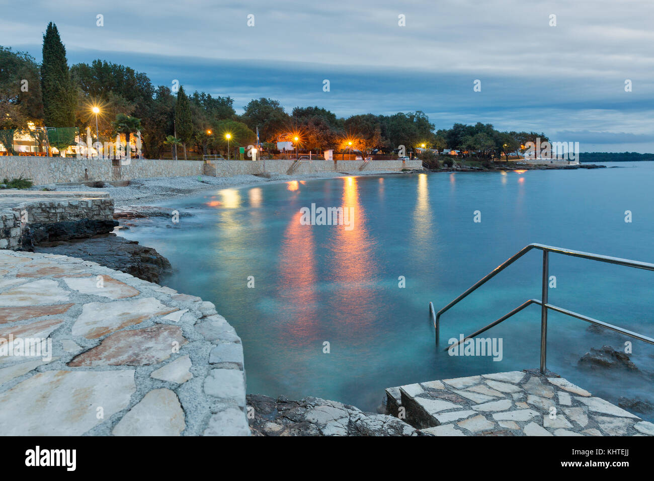 Sumer mediterranea resort con mare adriatico spiaggia rocciosa a sera. Istria, Croazia Foto Stock