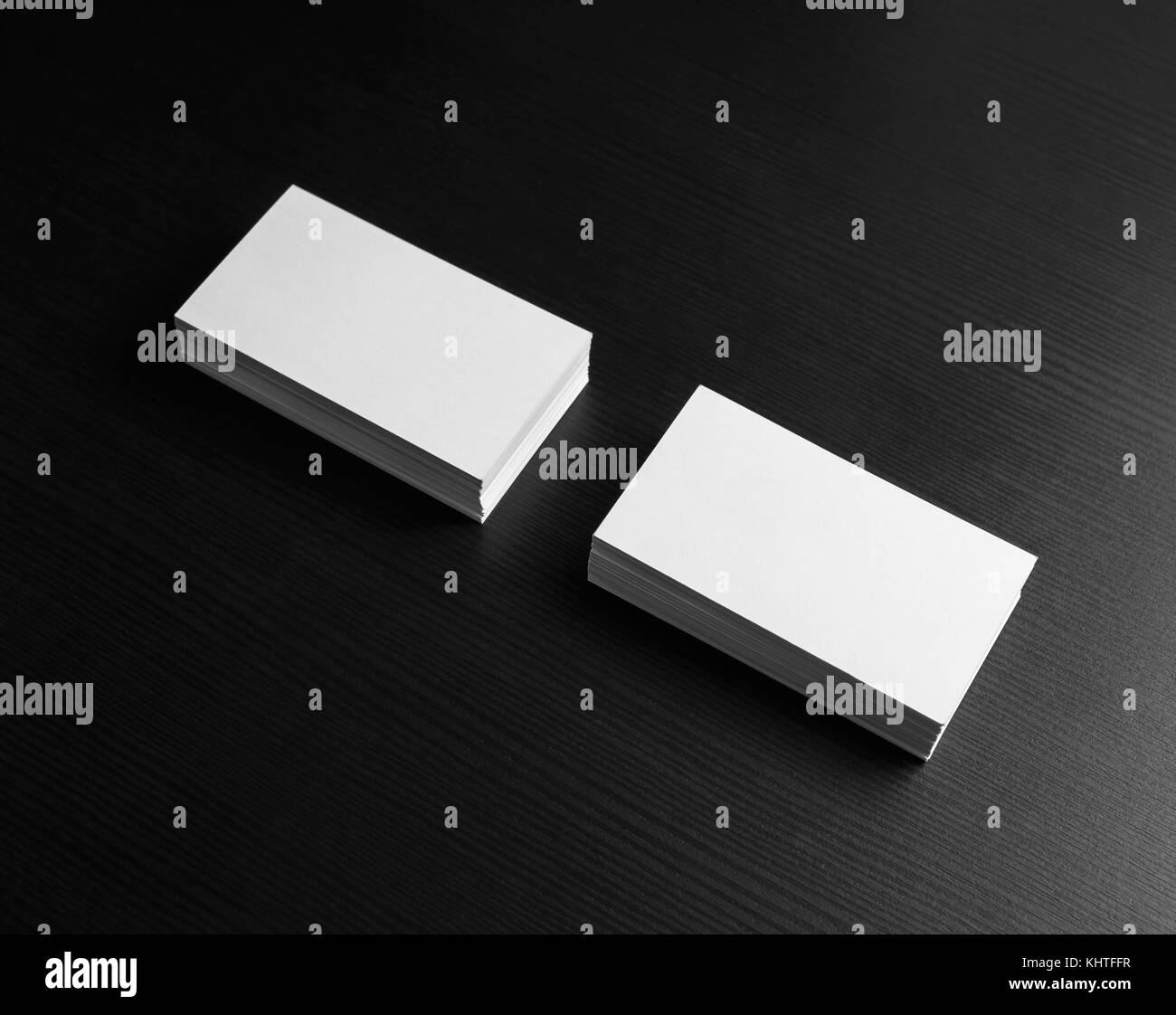 Foto di blank business cards su tavoli in legno nero sfondo. per la progettazione di presentazioni e portafogli. mock-up per l'identità del marchio. Foto Stock