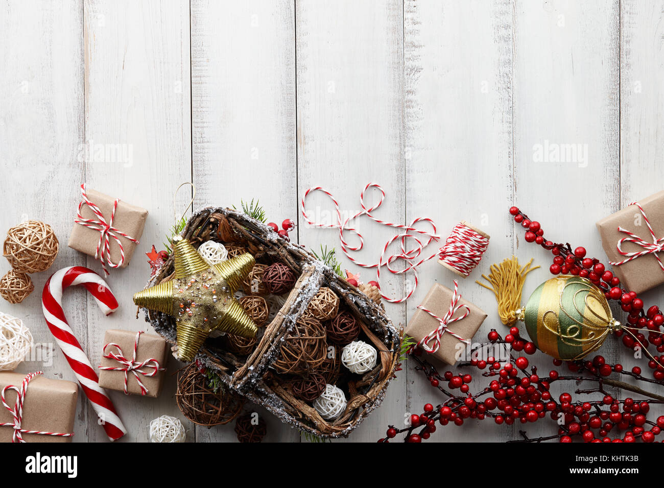 Natale palle di rattan nel cestello, golden giocattoli, decorazioni, presenta e confezioni regalo avvolto in carta kraft bianca su sfondo di legno, spazio di copia Foto Stock