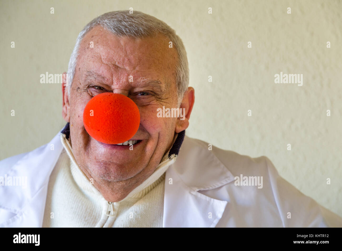 Il vecchio medico di campagna con clown naso rosso sorridente Foto Stock