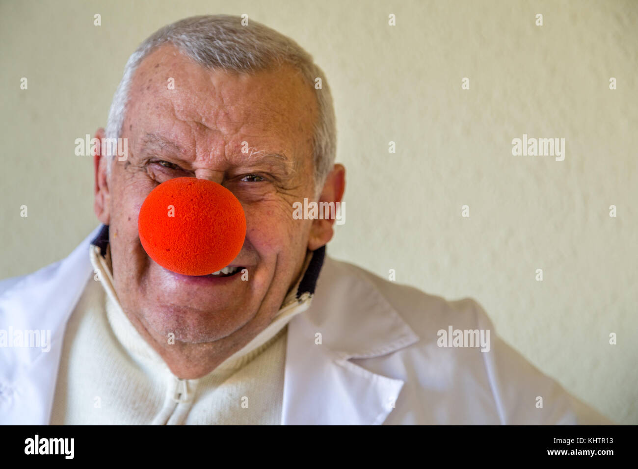 Il vecchio medico di campagna con clown naso rosso sorridente Foto Stock