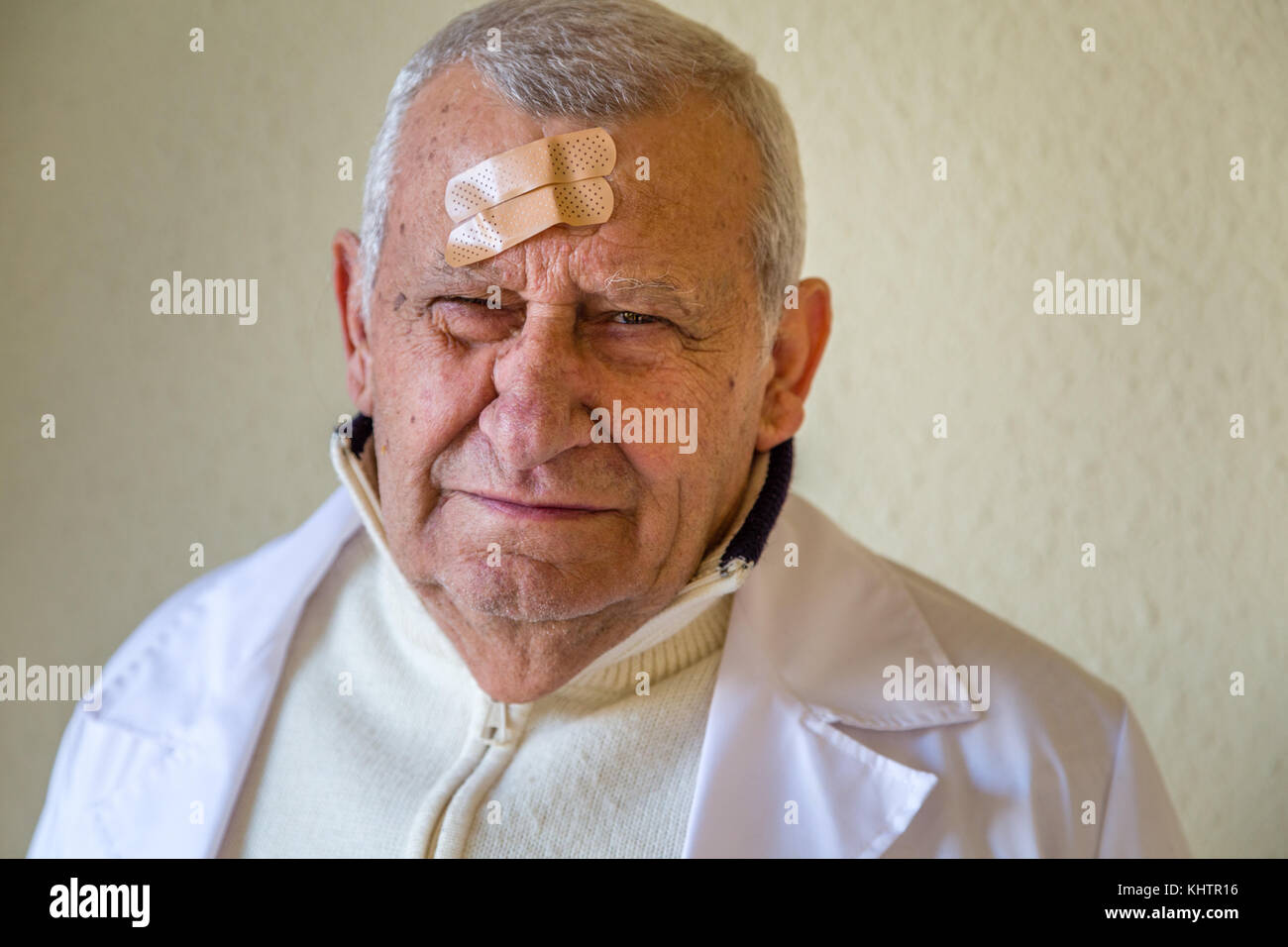 Il vecchio medico con patch sulla fronte Foto Stock