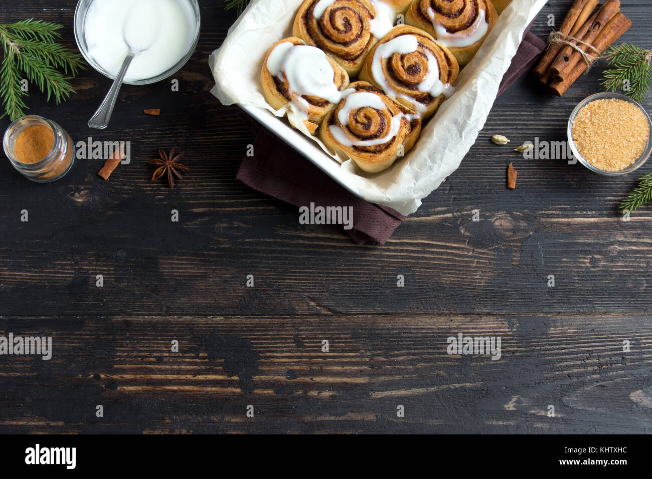 Panini alla cannella o cinnabon per natale. in casa tradizionale festivo invernale ciambelle dolci di pasticceria sul cibo in legno scuro con sfondo spazio copia. Foto Stock