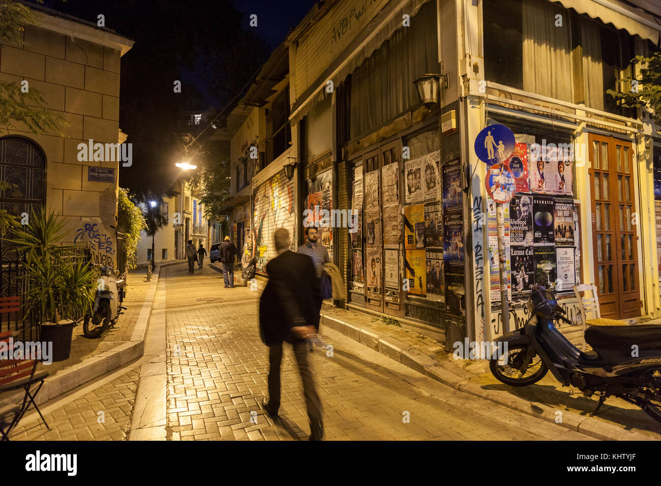 Athens, Grecia - 3 novembre 2017: angolo della costruzione nel quartiere Psyri di Atene dal centro città, a sinistra per il decadimento e la rovina, con gente che cammina nel buio Foto Stock