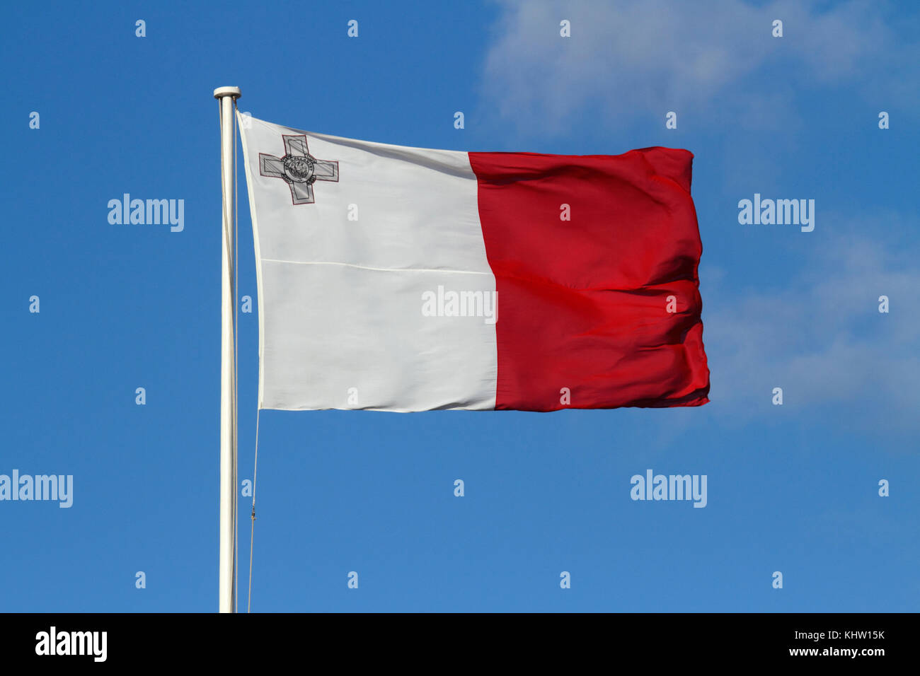 La bandiera nazionale di Malta vola in un forte vento su uno sfondo blu, con la Croce di Giorgio in un angolo. Colori maltesi. Foto Stock