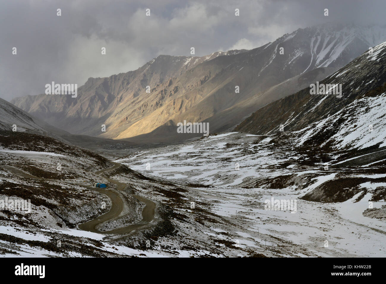 Coperte di neve valle di montagna con una strada di campagna la serpentina sul versante sinistro. Foto Stock