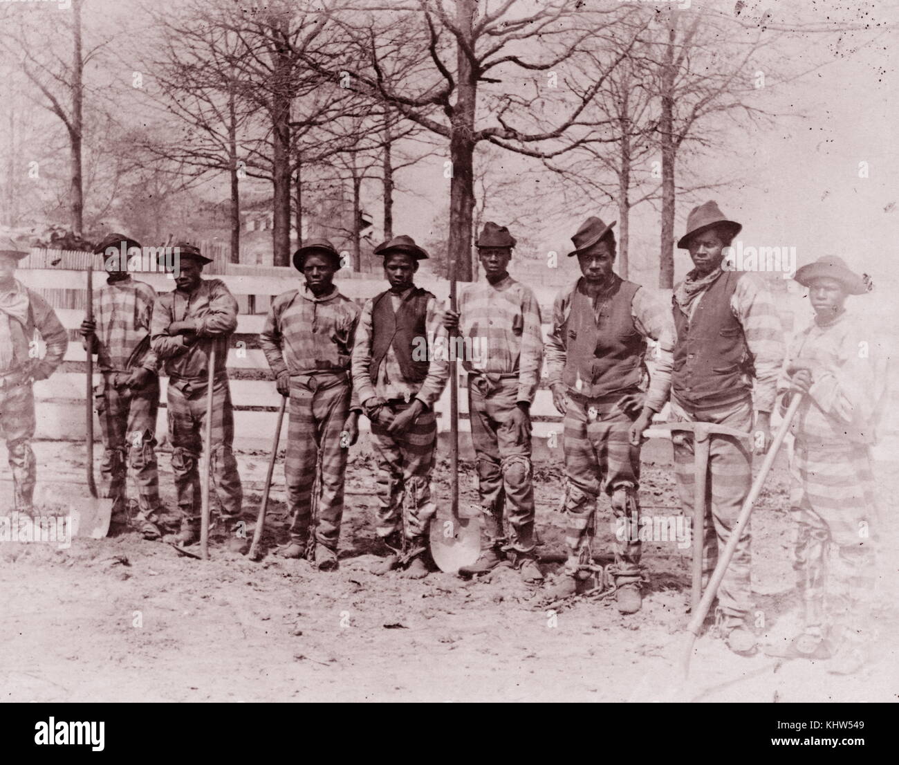 Stampa fotografica di nove americano africano uomini pone in piedi lungo la recinzione. Datata del XIX secolo Foto Stock