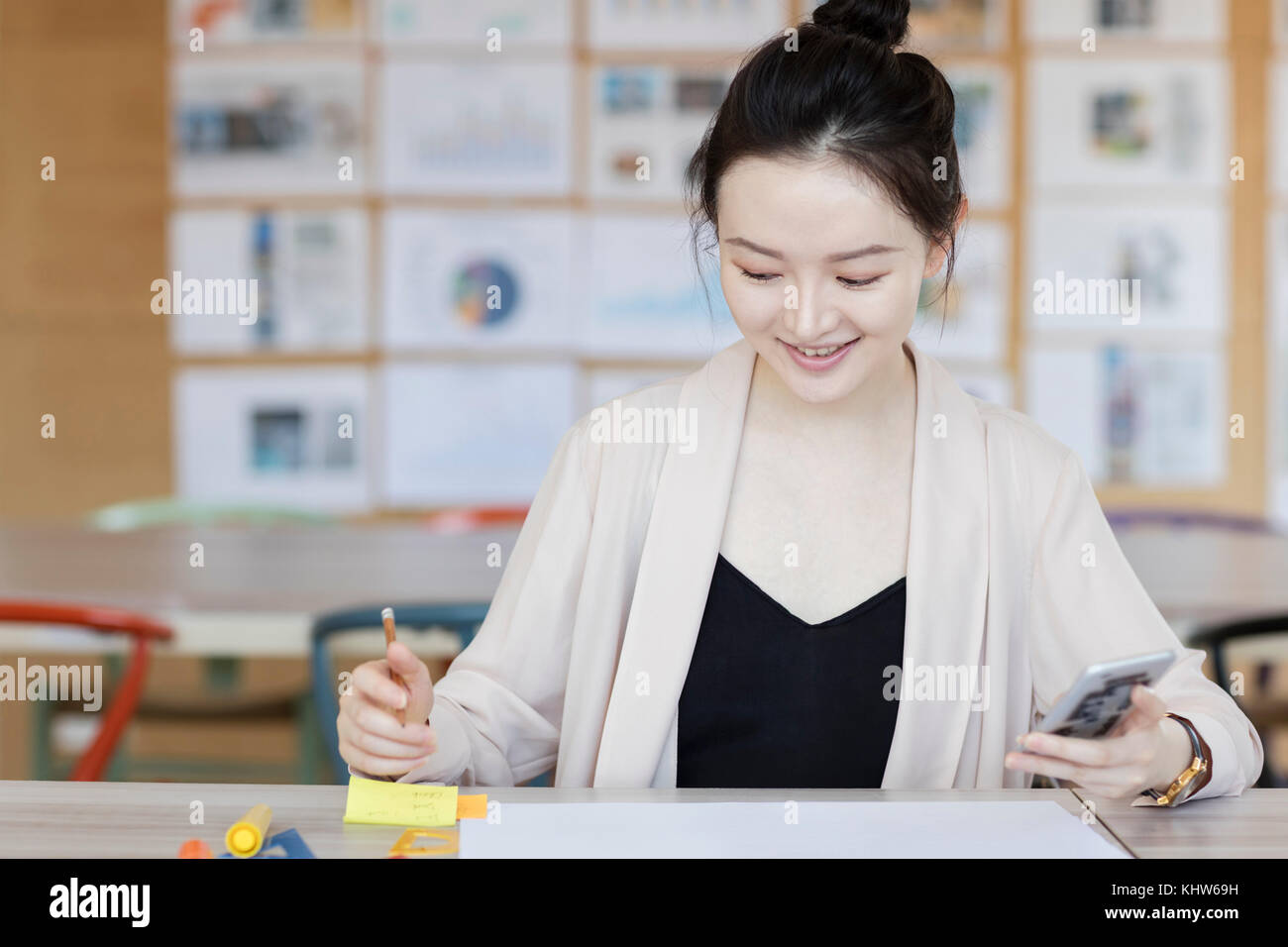 Studenti che lavorano utilizzando il telefono cellulare in classe Foto Stock