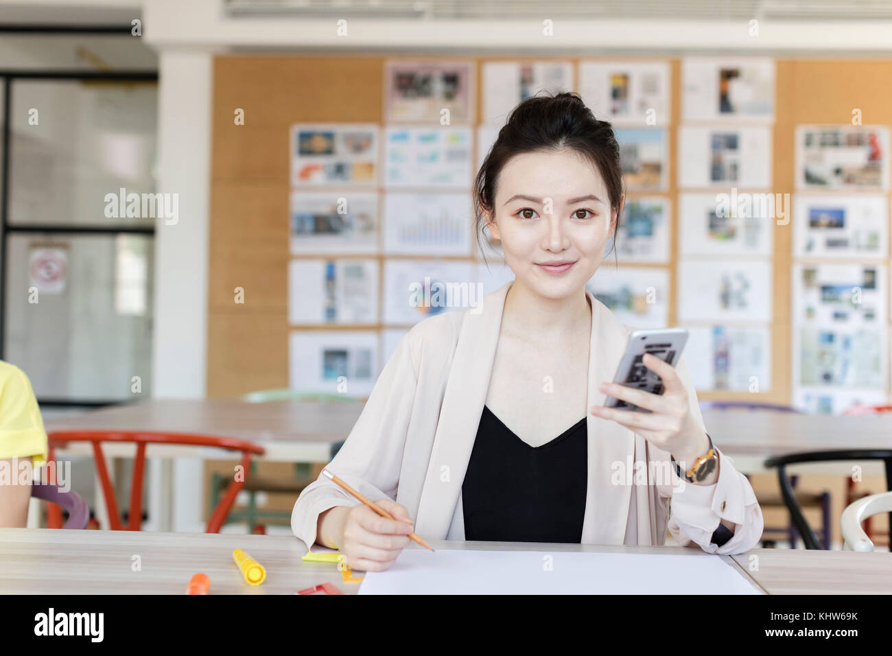 Studenti che lavorano utilizzando il telefono cellulare in classe Foto Stock
