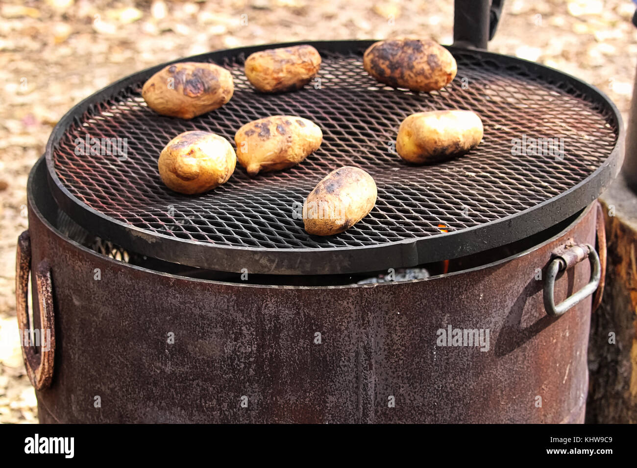 Rendendo le patate al forno in un accampamento grill. Foto Stock