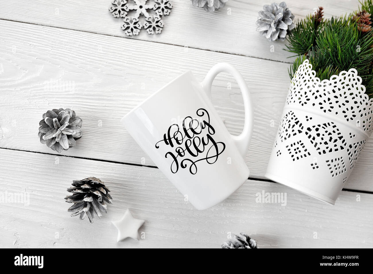 Testo di natale holly jolly su una tazza di bianco con decorazioni di Natale. flat laico, top view photo mockup Foto Stock