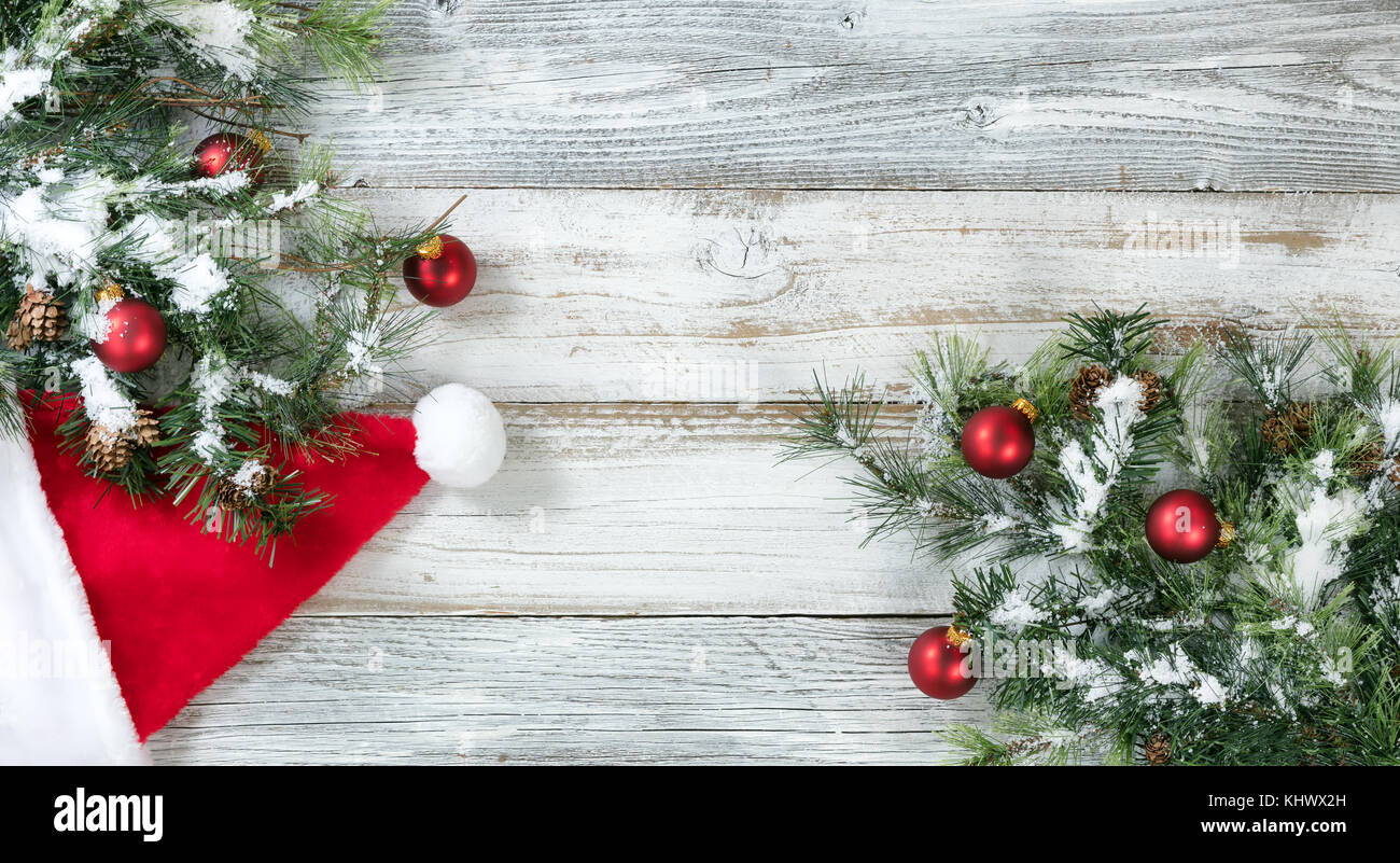 Natale ruvida abete, cappello da Babbo Natale e neve su weathered bianco  sullo sfondo di legno Foto stock - Alamy