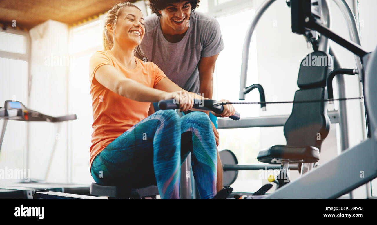 Personal trainer dando istruzioni in palestra Foto Stock