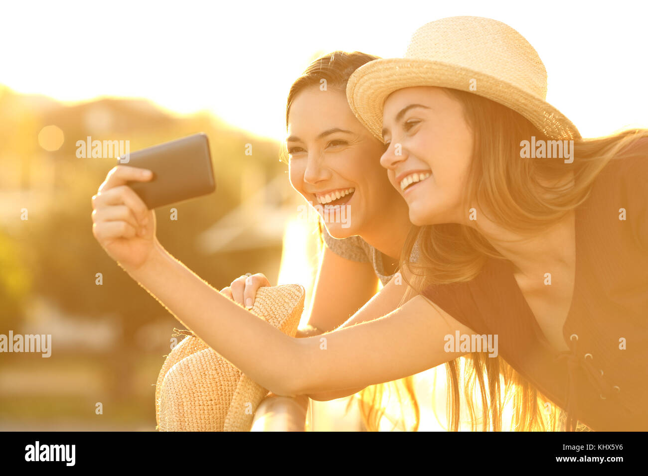 Due amici turistica prendendo selfies con uno smart phone in un hotel con balcone sulla vacanze Foto Stock