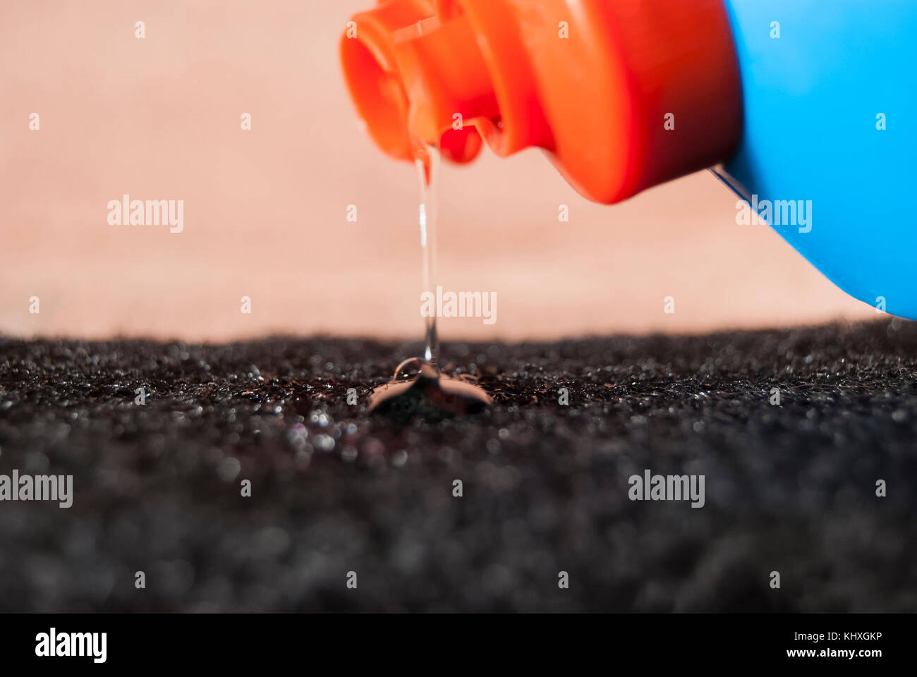 Il liquido per il lavaggio di stoviglie in una fiala di blu è versata sulla spugna. famiglia. Foto Stock