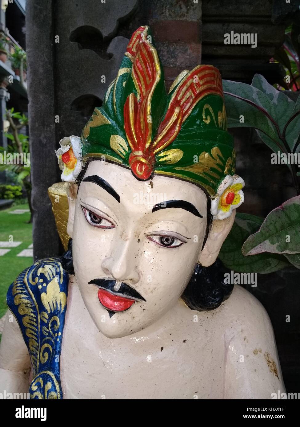 La testa e le spalle del dipinto luminosamente statua del maschio adoratore in abito tradizionale sull isola indonesiana di Bali Foto Stock