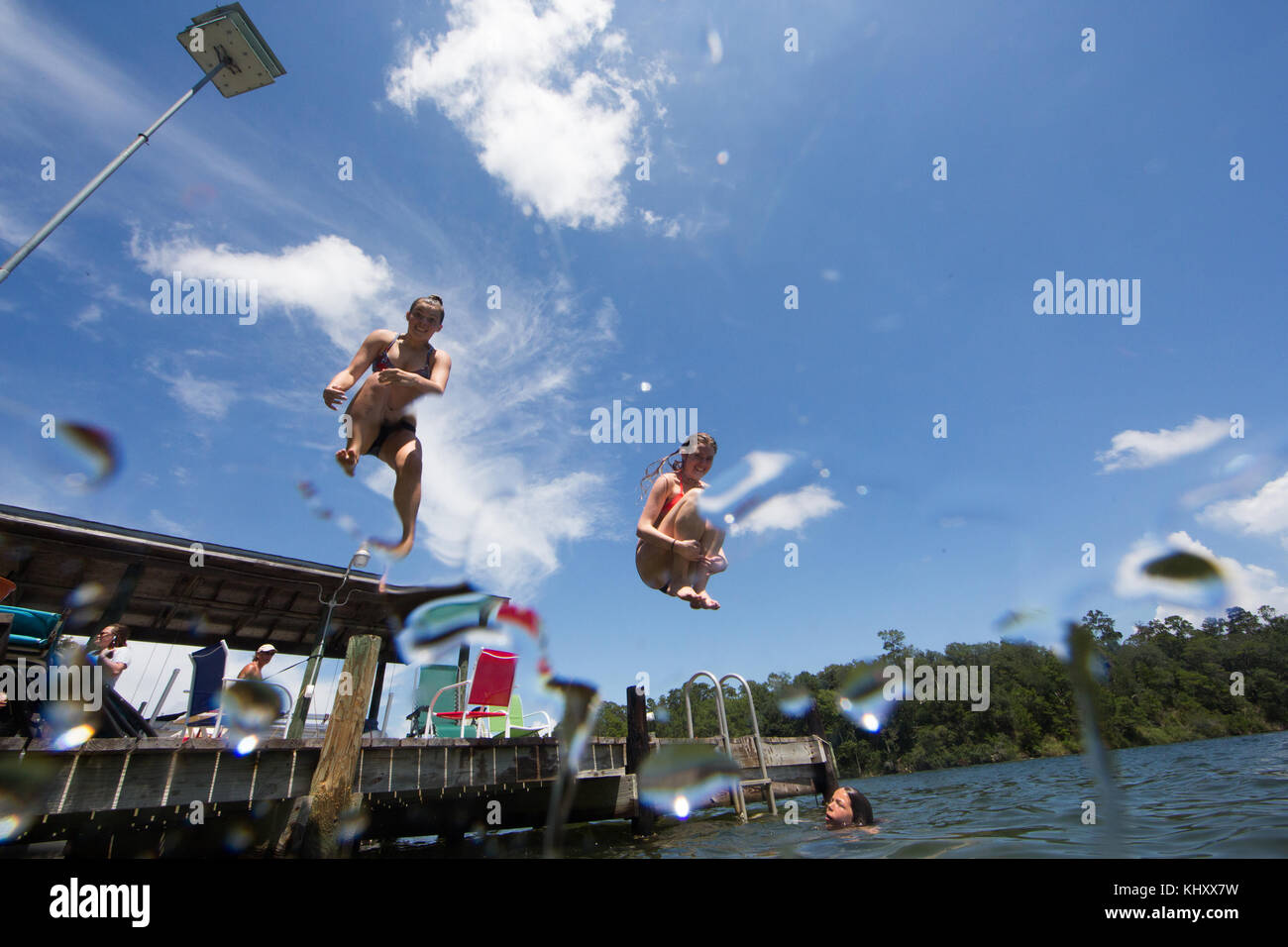 Gli adolescenti saltando nel lago a basso angolo di visione Foto Stock