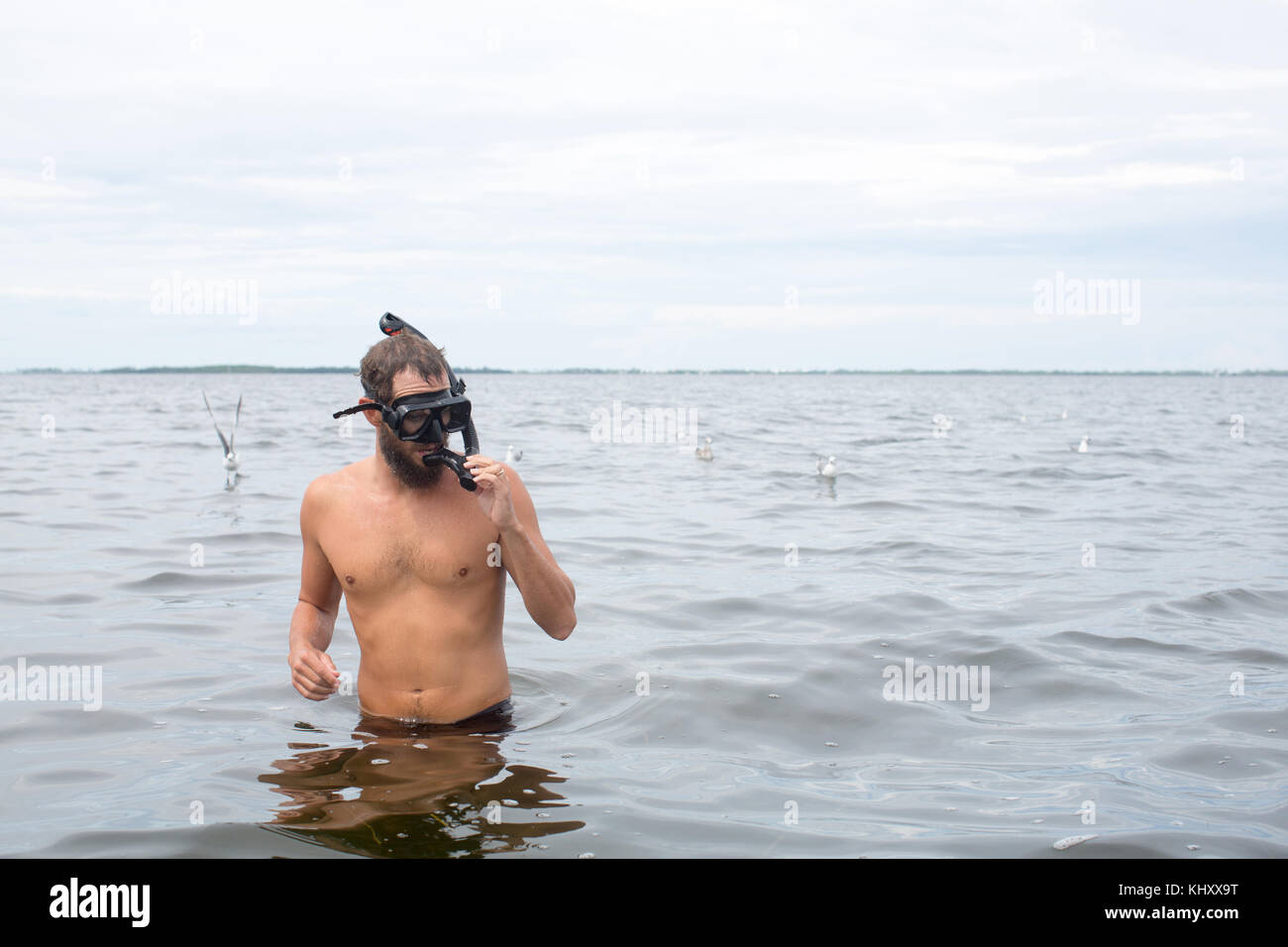 Uomo in acqua indossando maschera snorkel Foto Stock