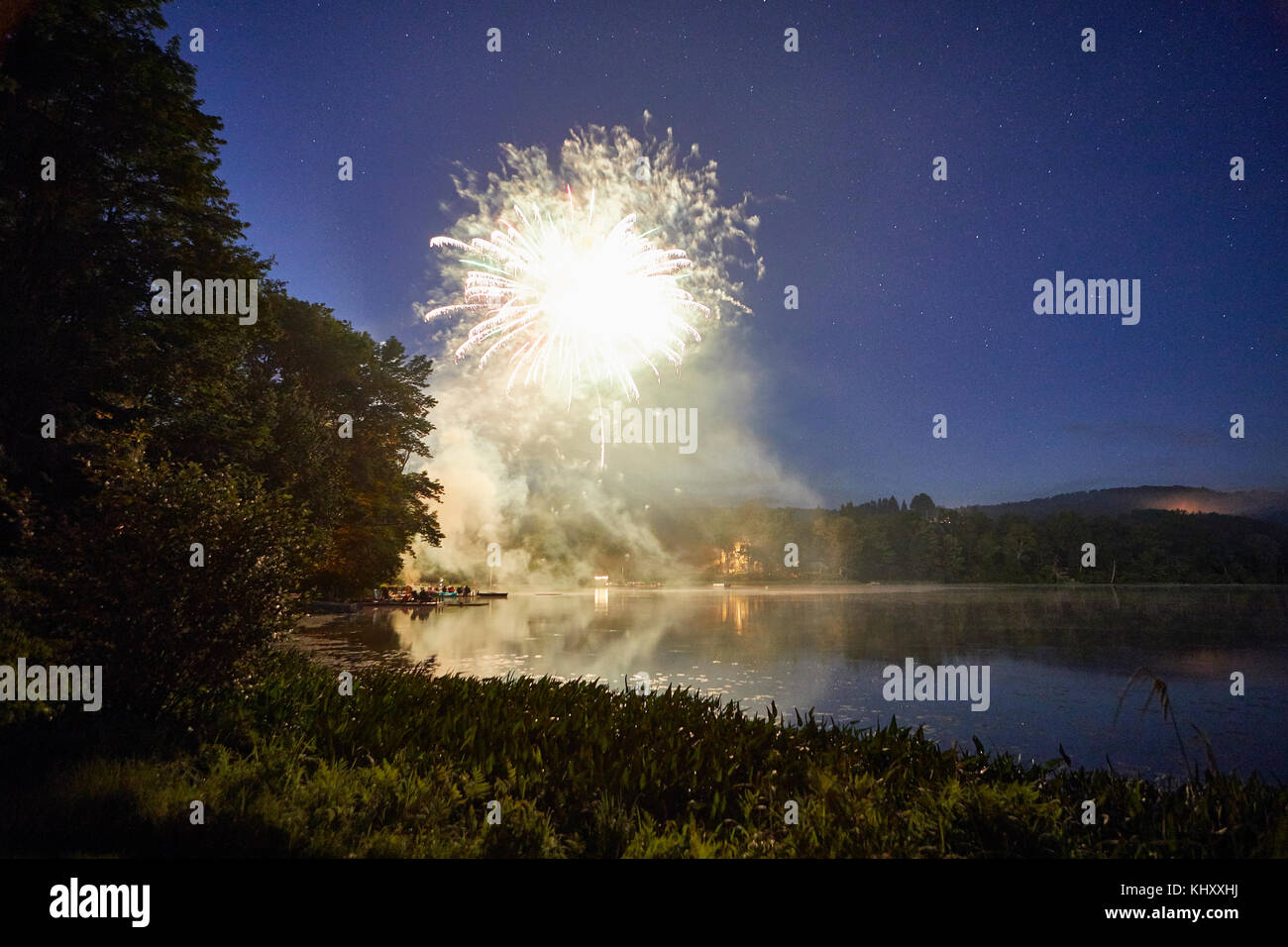 Esplosione di fuochi d'artificio sul lago al tramonto Foto Stock