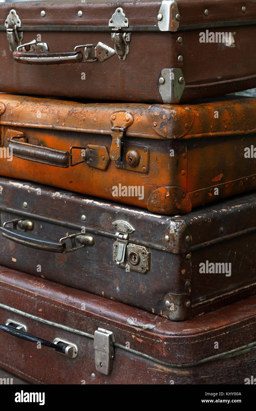 Stack di quattro vecchi antichi vintage grunge bagaglio da viaggio in pelle marrone trunk valigia, chiudere fino a basso angolo di vista laterale Foto Stock