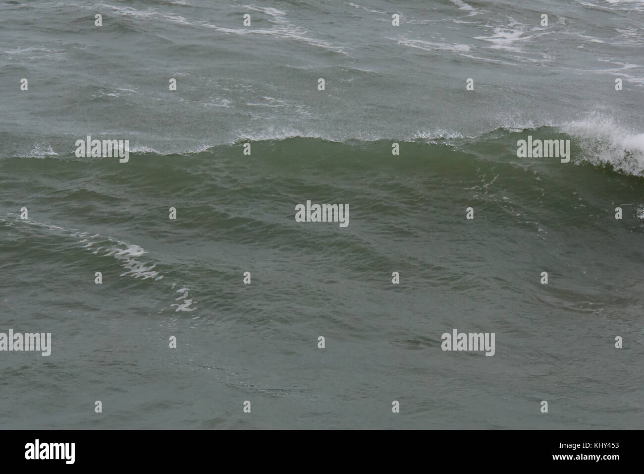 Un instabile e freddo guardando il mare in tempesta meteo instabile con creste bianche per le onde e gli interruttori automatici in rotolamento come navigare e rigonfiare. Foto Stock