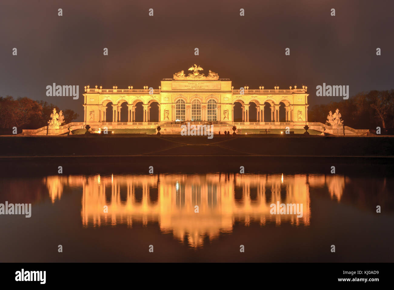 Gloriette in palazzo Schoenbrunn giardini, Vienna, Austria la notte come si riflette nell'acqua. Foto Stock