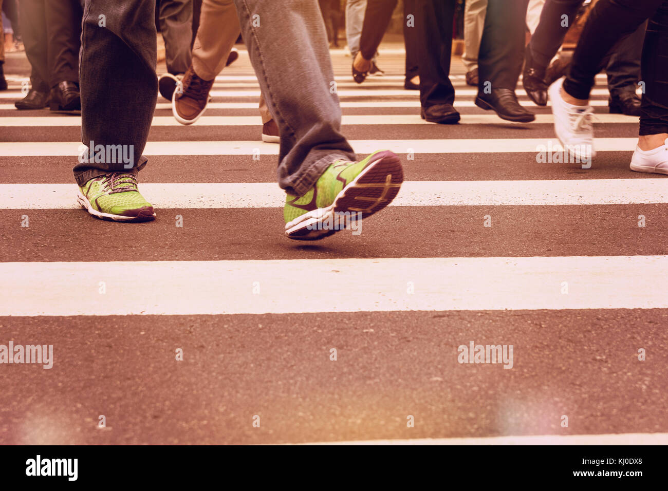 La persona che indossa le scarpe running. l uomo attraversando la strada in  città e utilizzando il crosswalk Foto stock - Alamy