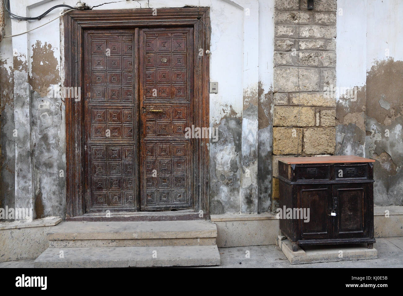 La porta è realizzata in stile antico, con motivi scolpiti e un manico di bronzo. L'armadietto è dello stesso stile e con un ferro da stiro lock.stile grunge Foto Stock