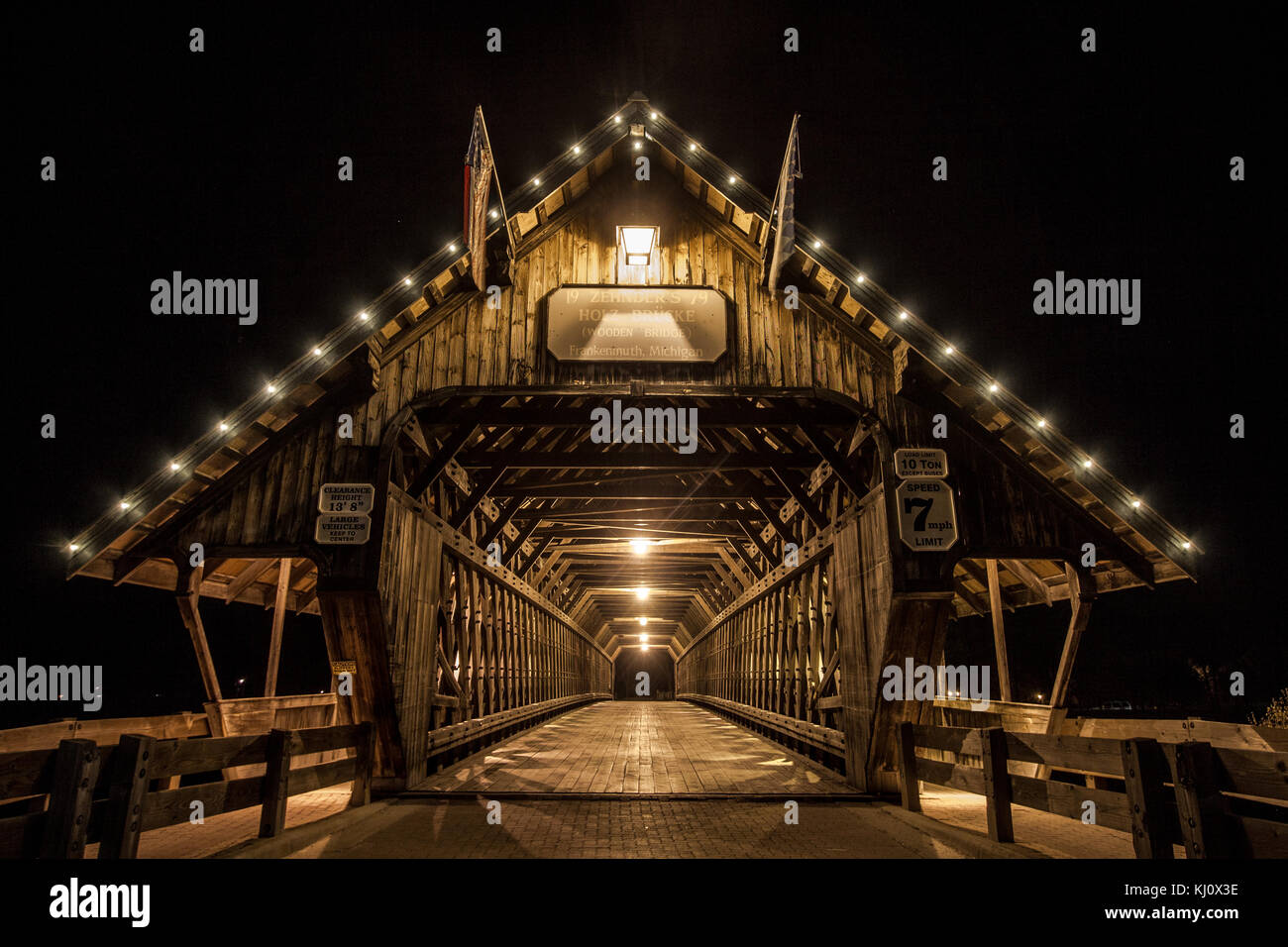 Punto di riferimento in legno ponte coperto di notte nel centro cittadino di frankenmuth, Michigan. Il ponte di sola andata è aperto al traffico veicolare. Foto Stock