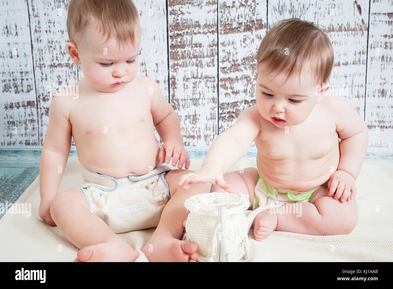 Due bambini piccoli, un ragazzo e una ragazza in stoffa naturale pannolini, naturale swaddling, eco-friendly tessuti di cotone Foto Stock