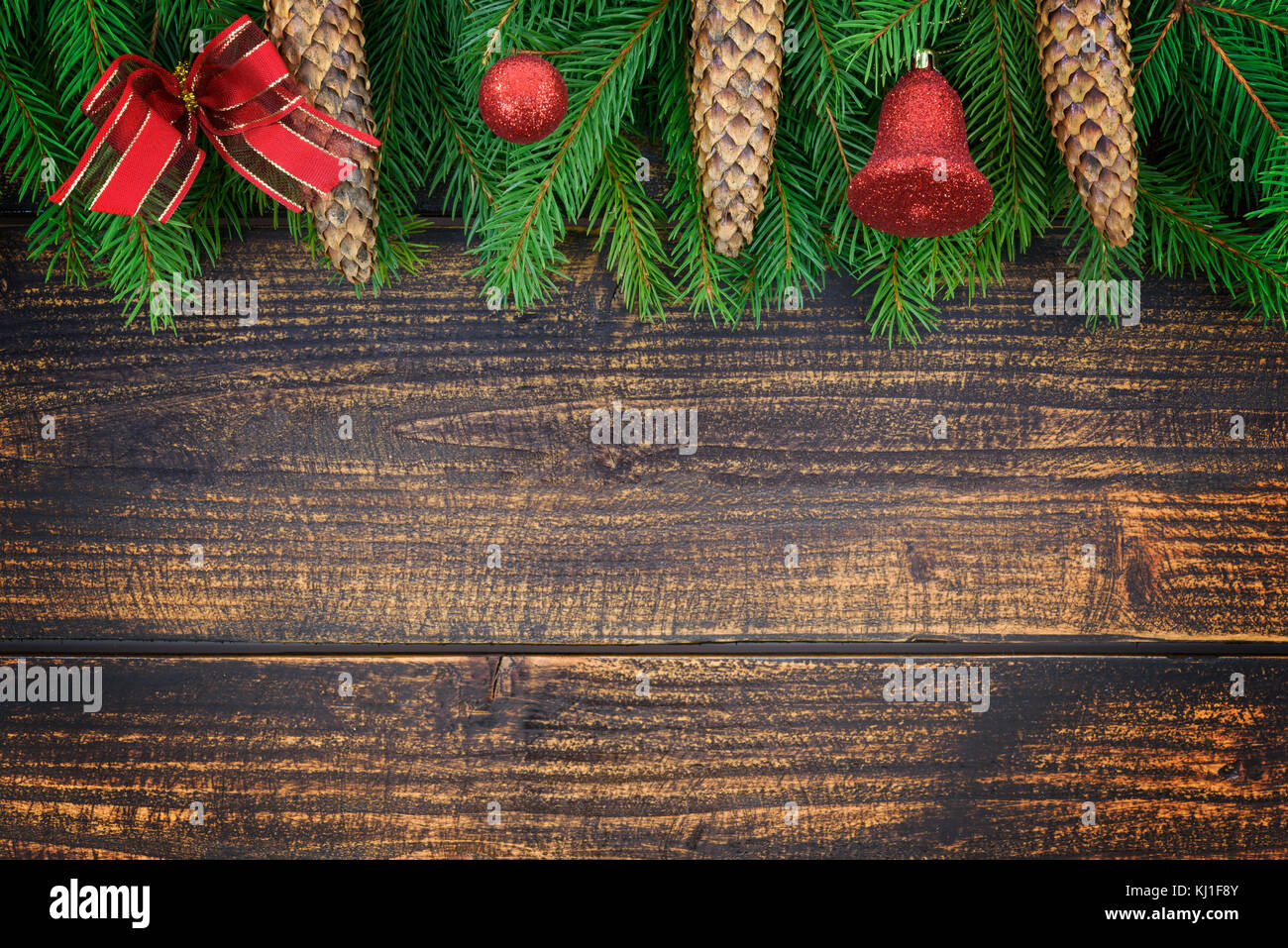Decorazione di natale concetto - rami di abete rosso con coni e ornamenti natale su un vecchio vintage in legno doghe con spazio di copia ( alta dettagli). Foto Stock