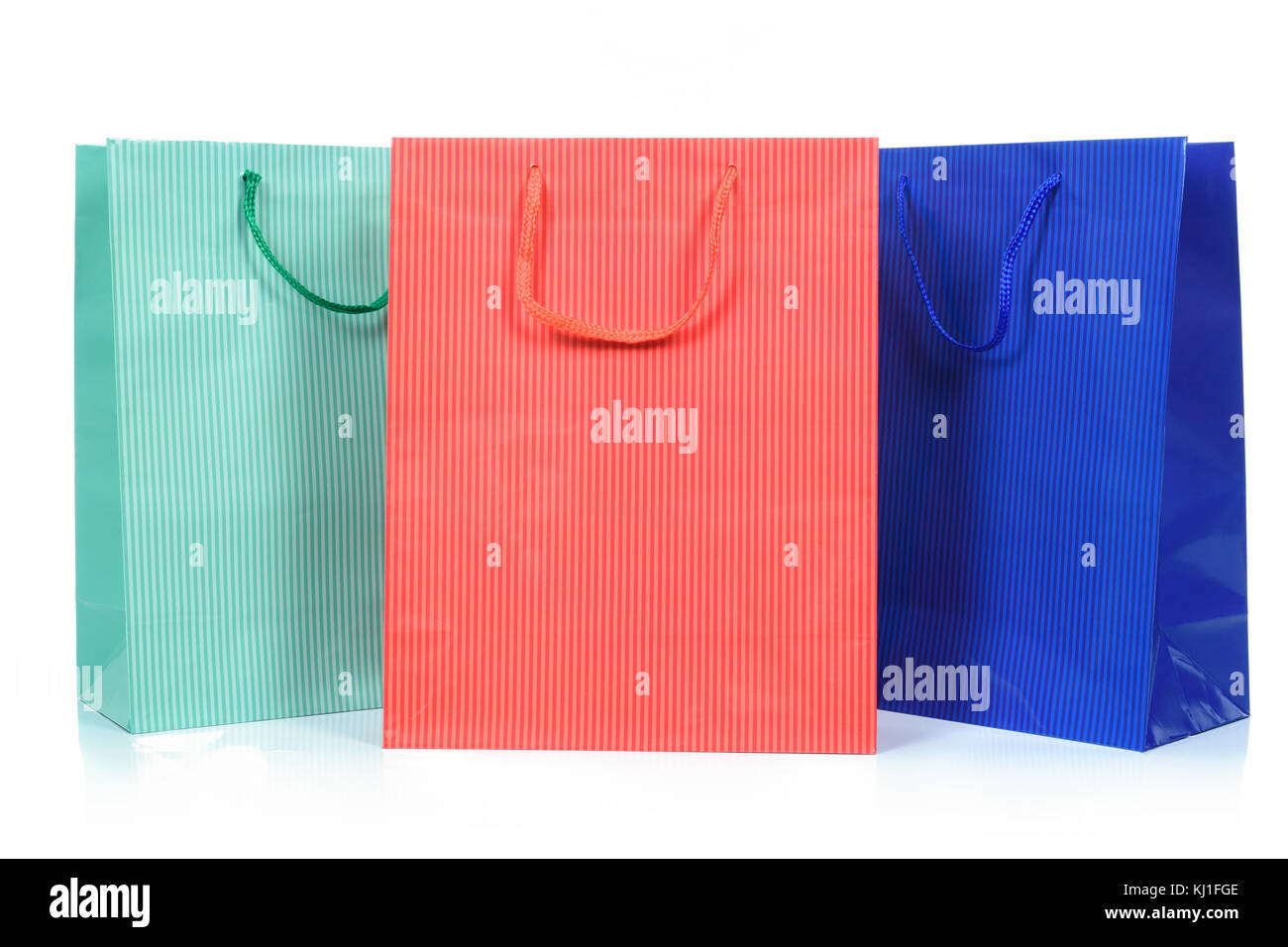 Tre borse per la spesa in diversi colori in close up e isolate su uno sfondo bianco. Foto Stock