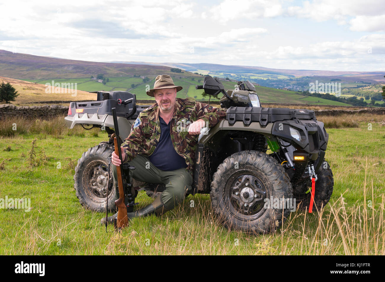 Un uomo seduto su un quad (ATV) fuori tiro facendo controllo vermin a Weardale in County Durham, nel Nord Est dell'Inghilterra. Foto Stock