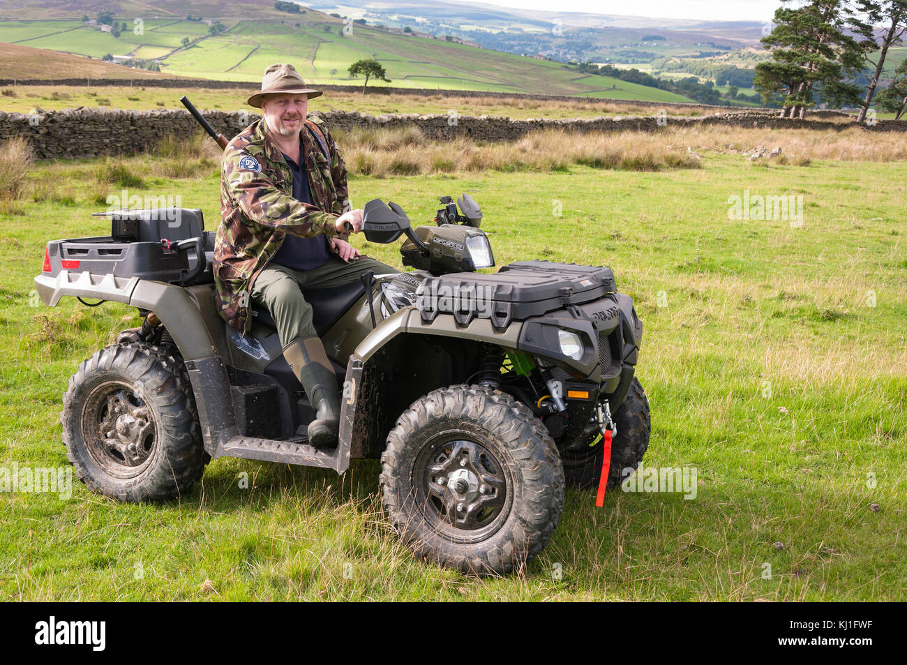 Un uomo seduto su un quad (ATV) fuori tiro facendo controllo vermin a Weardale in County Durham, nel Nord Est dell'Inghilterra. Foto Stock