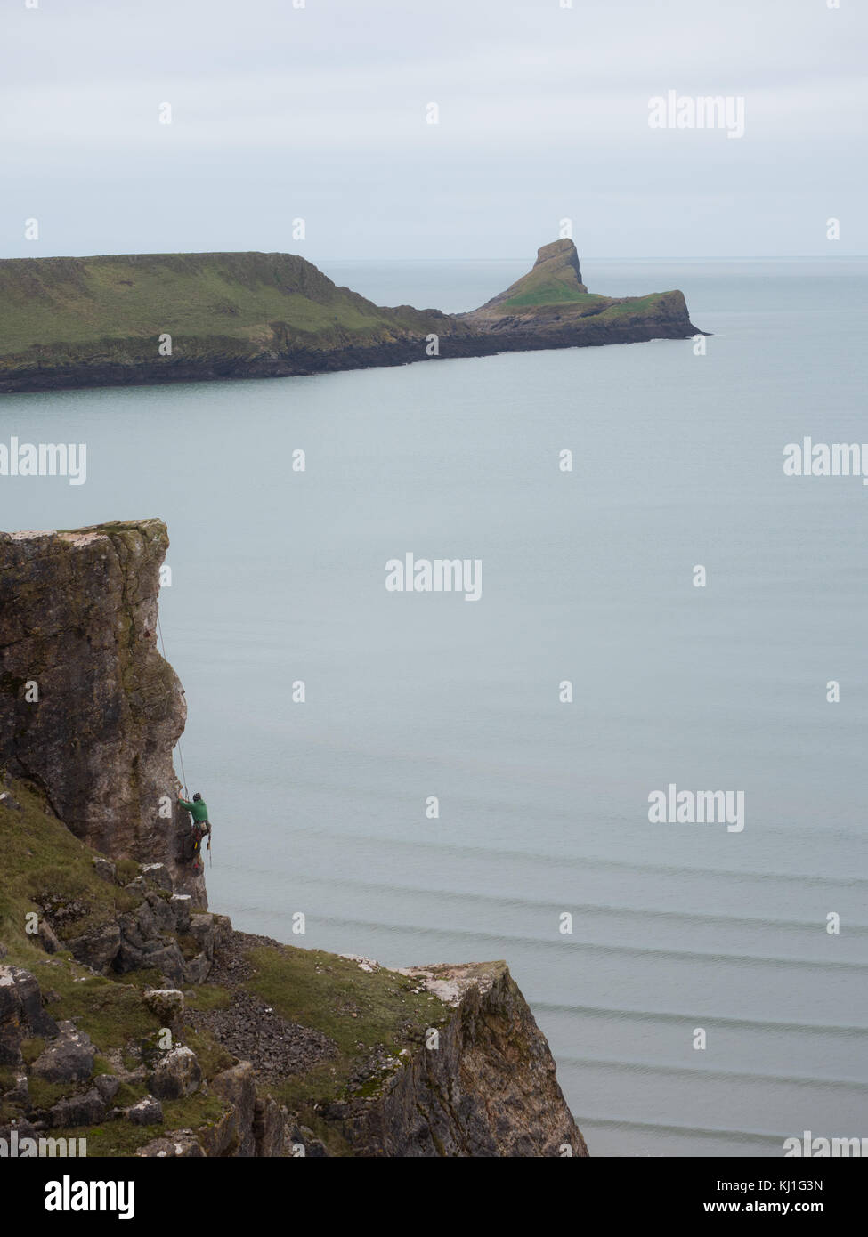 Un scalatore di pietra lo su una scogliera a Rhossili sulla Penisola di Gower Wales UK Foto Stock