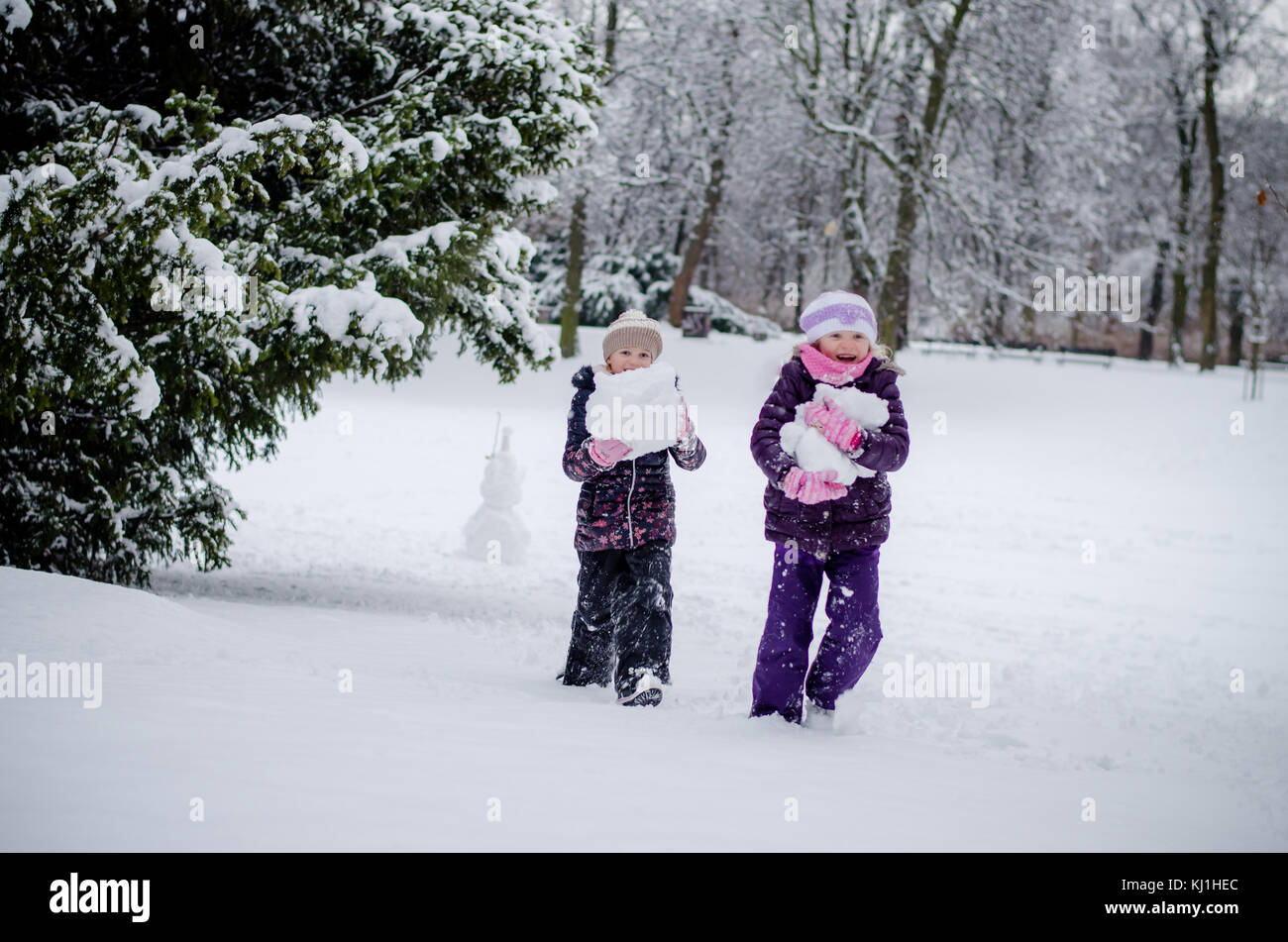 Due splendidi bambini ragazze sorelle giocando in winter park con le palle di neve Foto Stock