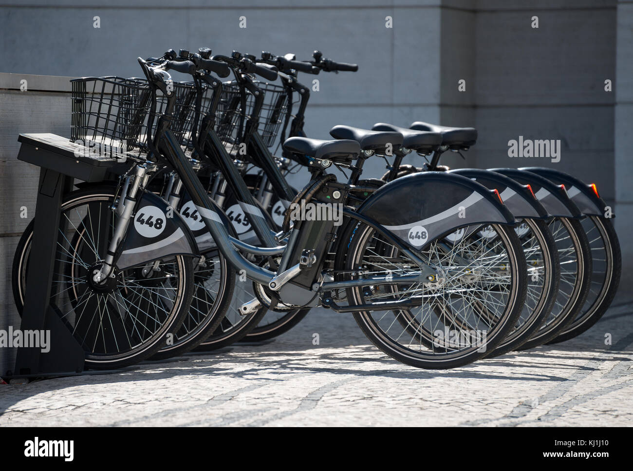 Parcheggio pubblico di biciclette a noleggio in città. Foto Stock