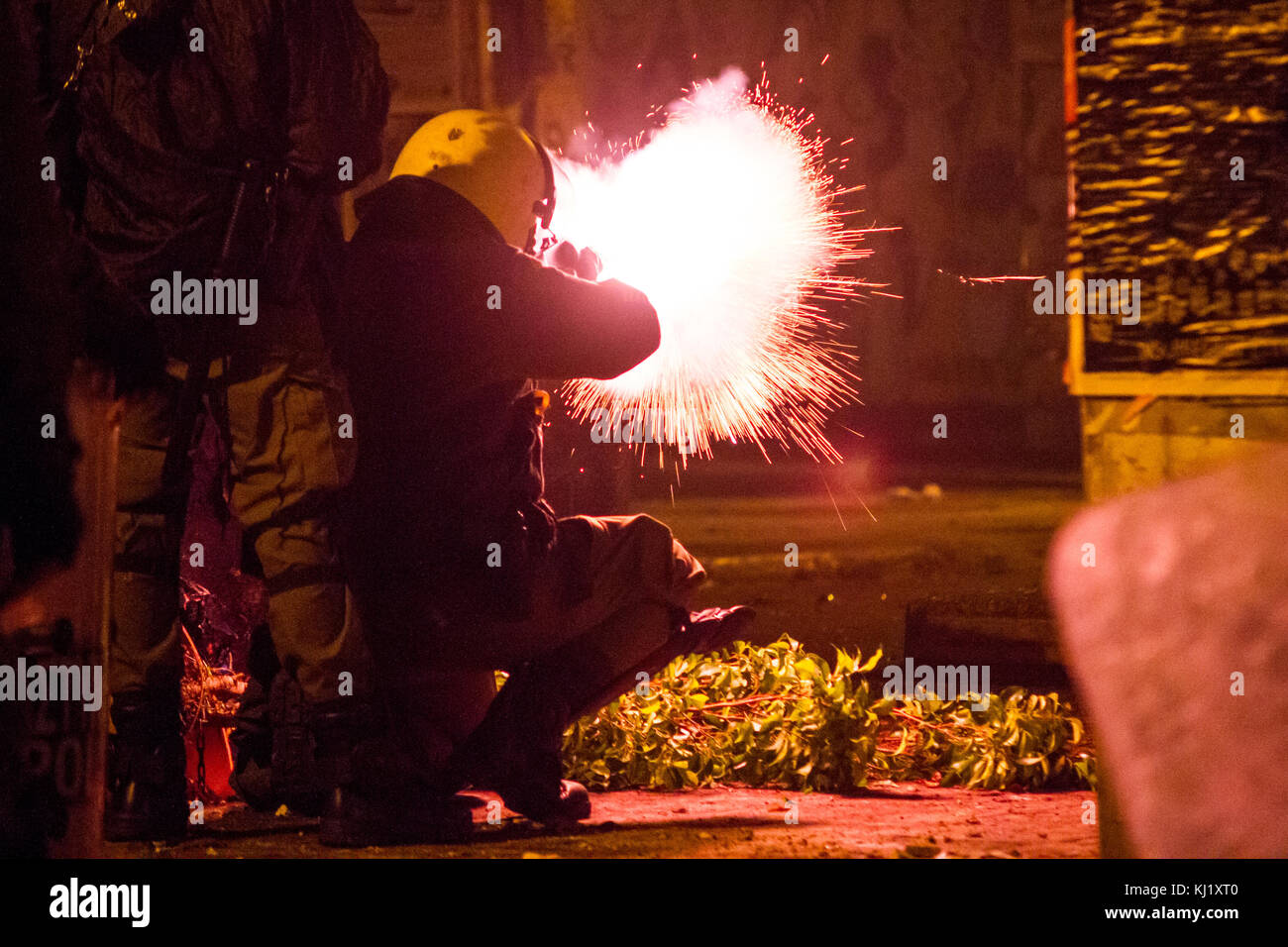 Una sommossa poliziotto spara una granata stun contro l'anti-gli autoritari. sinistra sindacati e anti-gli autoritari marzo verso l ambasciata degli Stati Uniti durante la commemorazione del politecnico insurrezione. dopo i tumulti di marzo ha avuto luogo nella regione di exarhia tra anti-gli autoritari e polizia. photo: cronos/kostas pikoulas Foto Stock