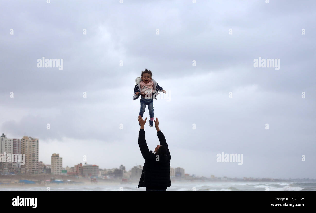 Gaza, striscia di Gaza. 21 Nov 2017. Un uomo palestinese porta suo figlio durante una giornata piovosa, al porto di Gaza. Credit: ATIA Darwish/APA Images/ZUMA Wire/Alamy Live News Foto Stock